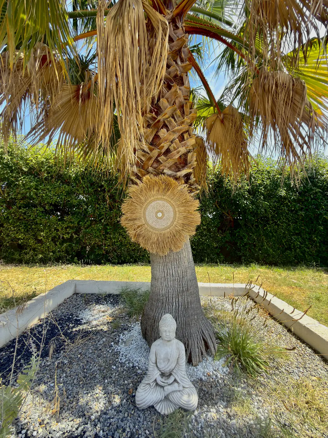 Juju Hat naturel Aura Bali installé dans un jardin au pied d'un palmier